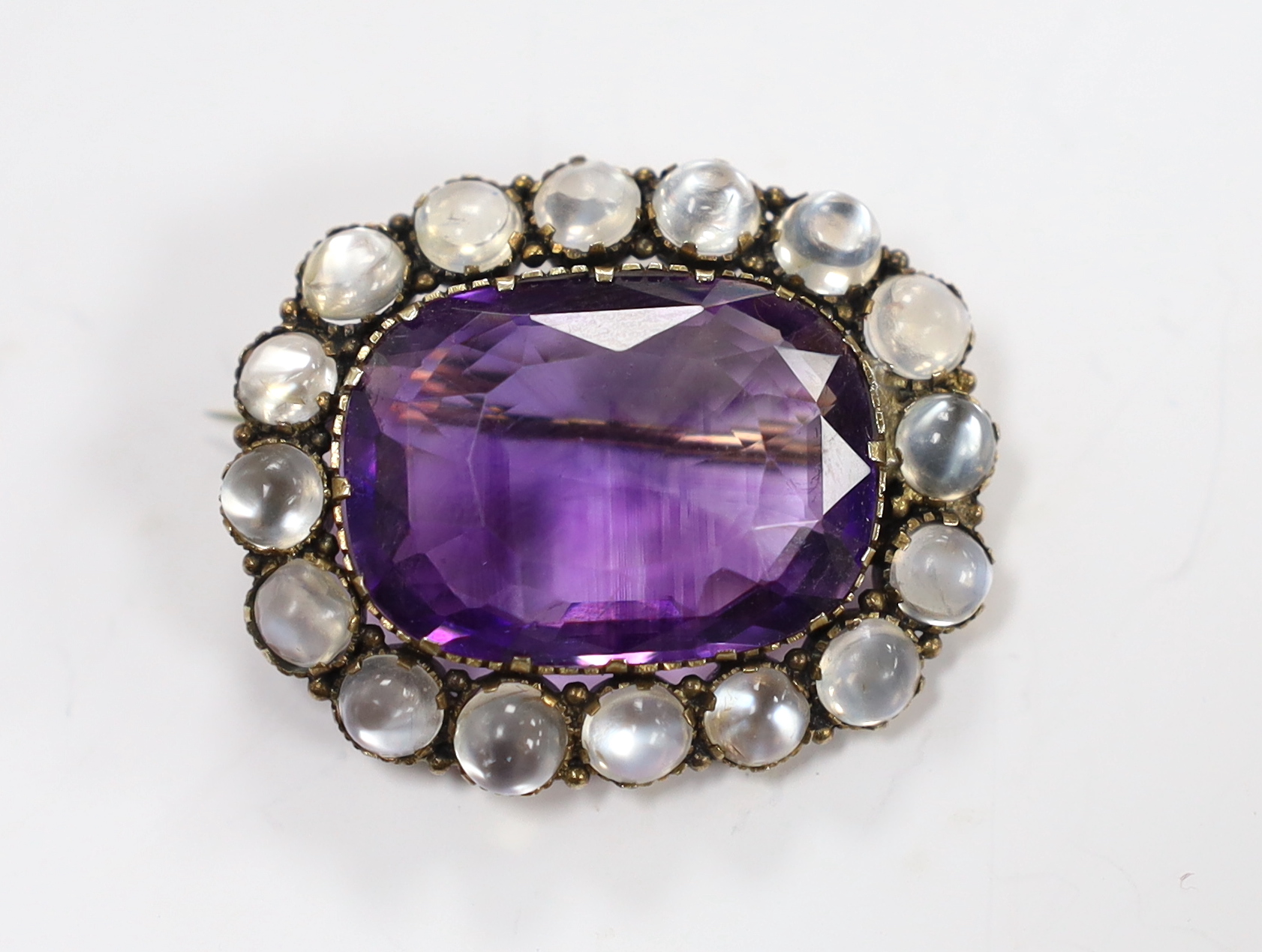 A yellow metal, amethyst and moonstone cluster set oval brooch, 34mm, gross weight 10.4 grams.